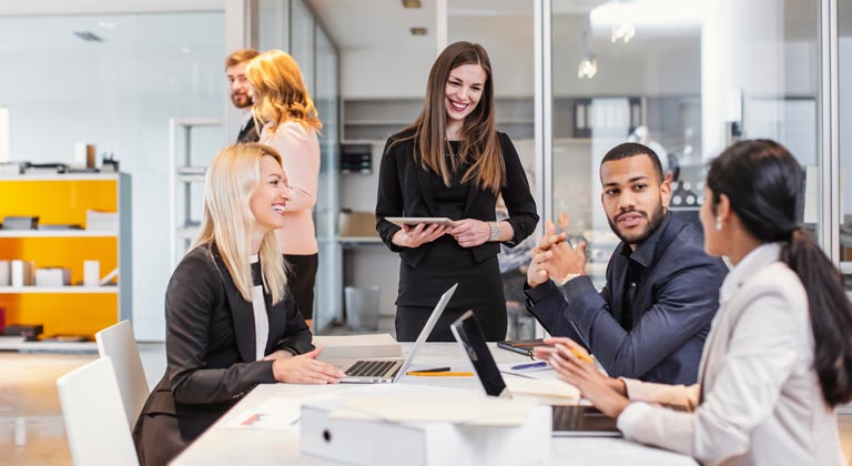 work team around white table with open laptops