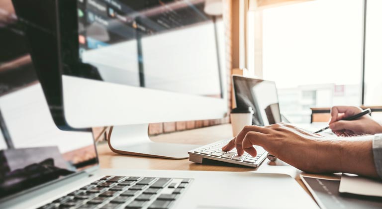 hand typing on keyboard at desk