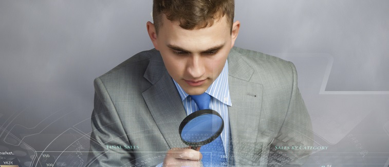detective using magnifying glass on digital graphs