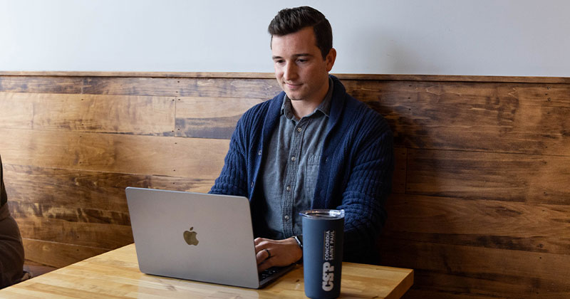 man in sweater at coffee shop booth