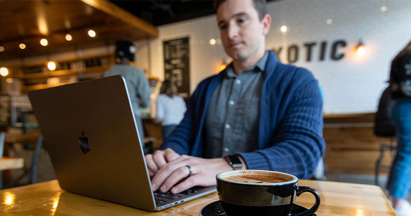 man in coffee shop at laptop