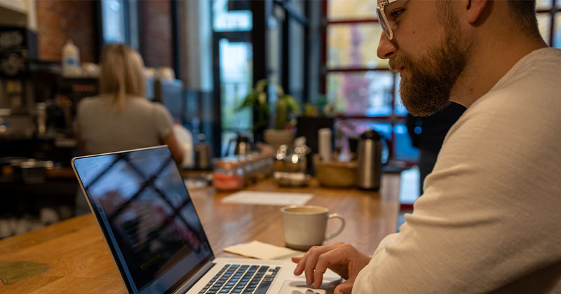 man at coffee shop with laptop