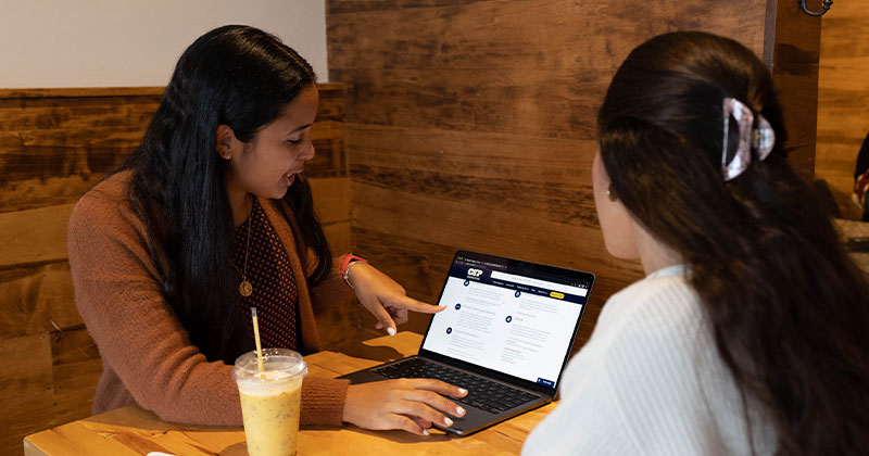 women at table looking at CSP website